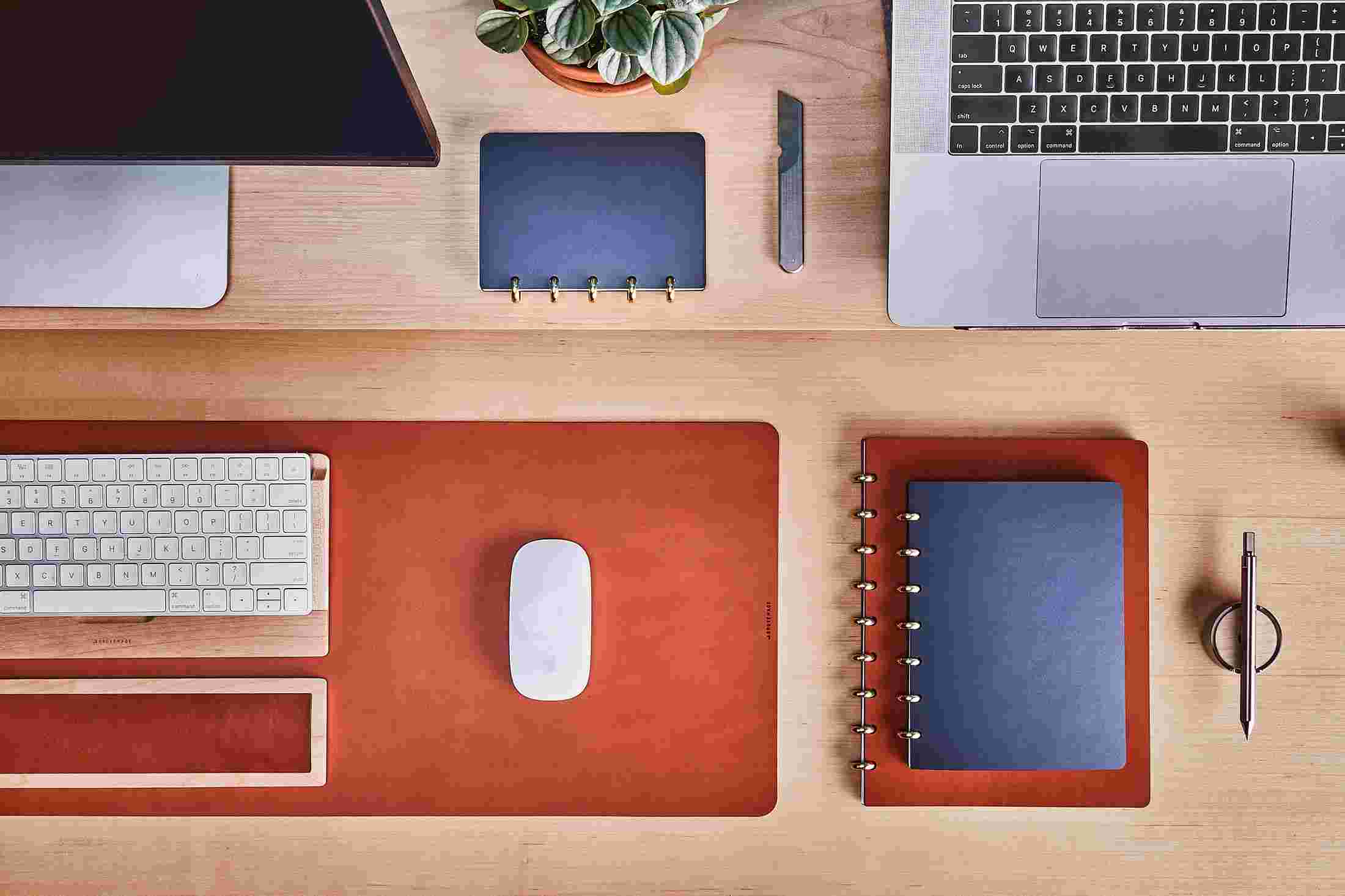 Overhead of the Grovemade Monitor Shelf with large and small discbound notebooks in navy blue and tan leather.