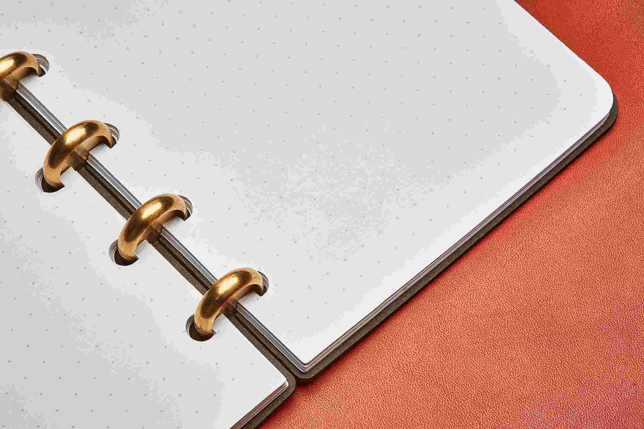 Close up detail showing the dot grid notebook lying completely flat on tan leather.