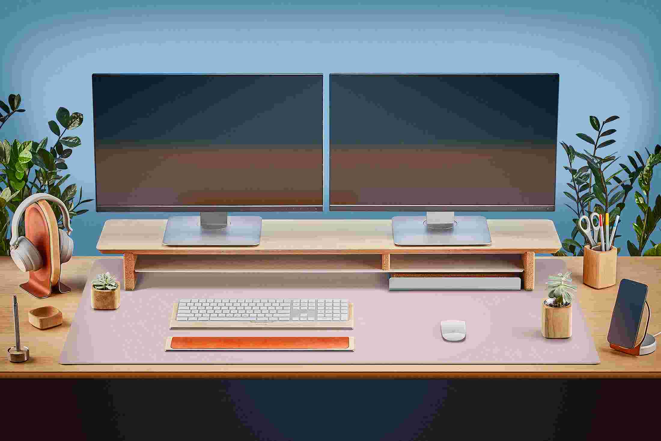 The Extra Large Matte Desk Pad in pink covering almost an entire desktop, in use with the Maple Desk Shelf System.