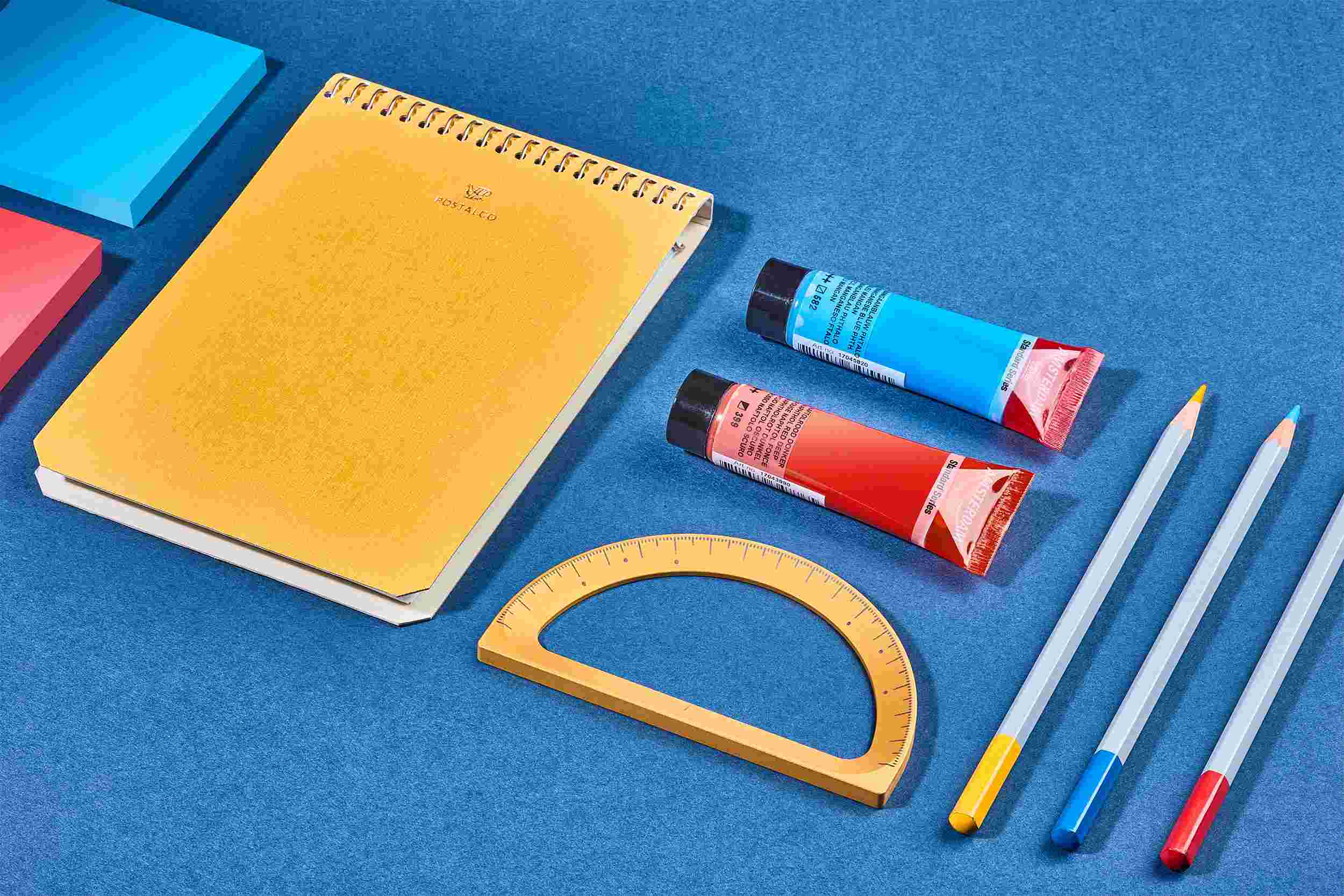 The Grovemade Gold Protractor on blue paper with crafting tools.