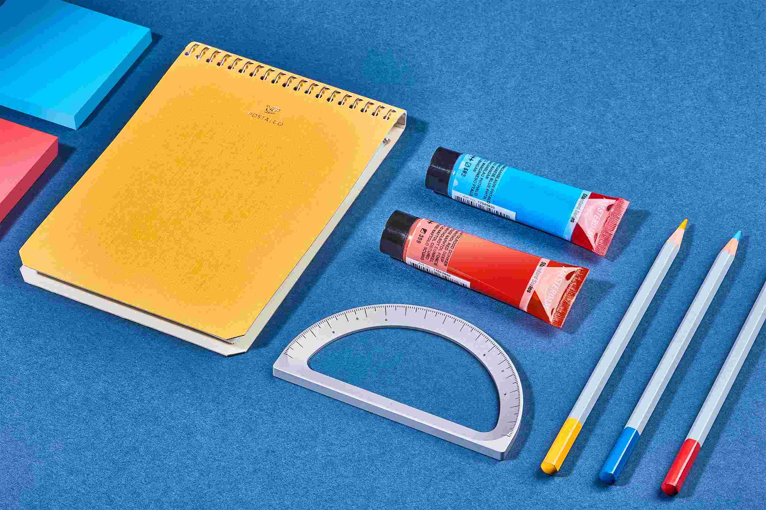 The Grovemade Silver Protractor on blue paper with crafting tools.