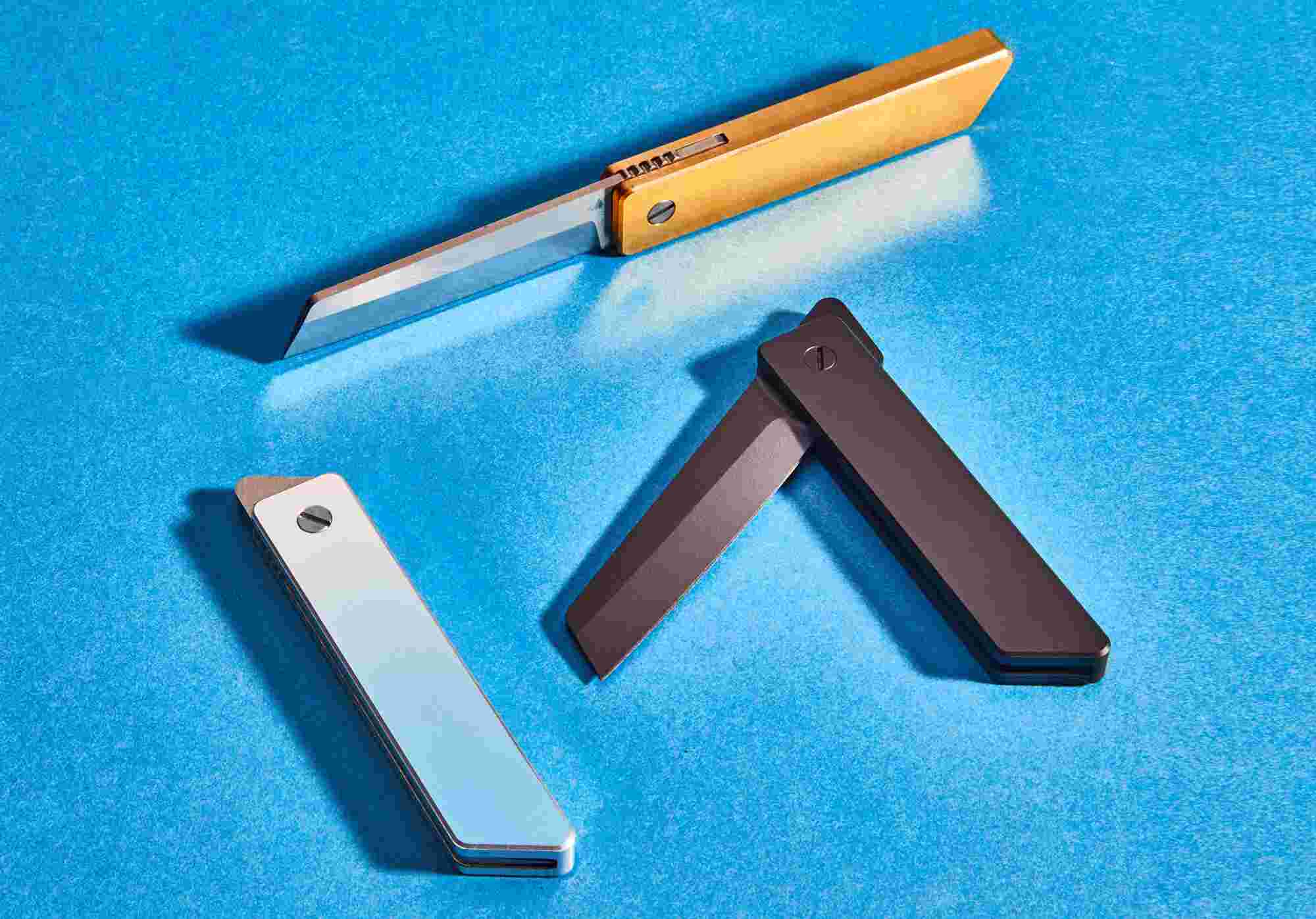 The Grovemade Minimalist Pocket Knife, in three different colors: silver aluminum, matte black, and classic brass.
