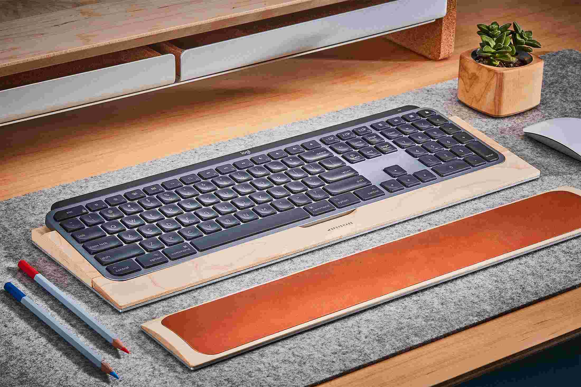 Side view detail of the steel and walnut wood keyboard tray for MX Keys.