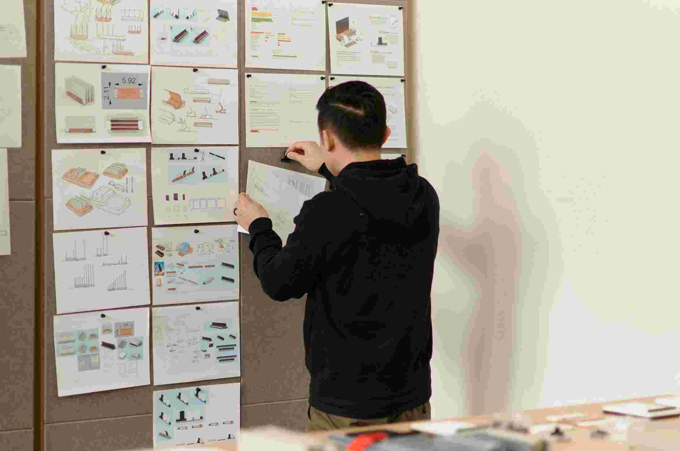 Matthew pins a sketch to the design board.