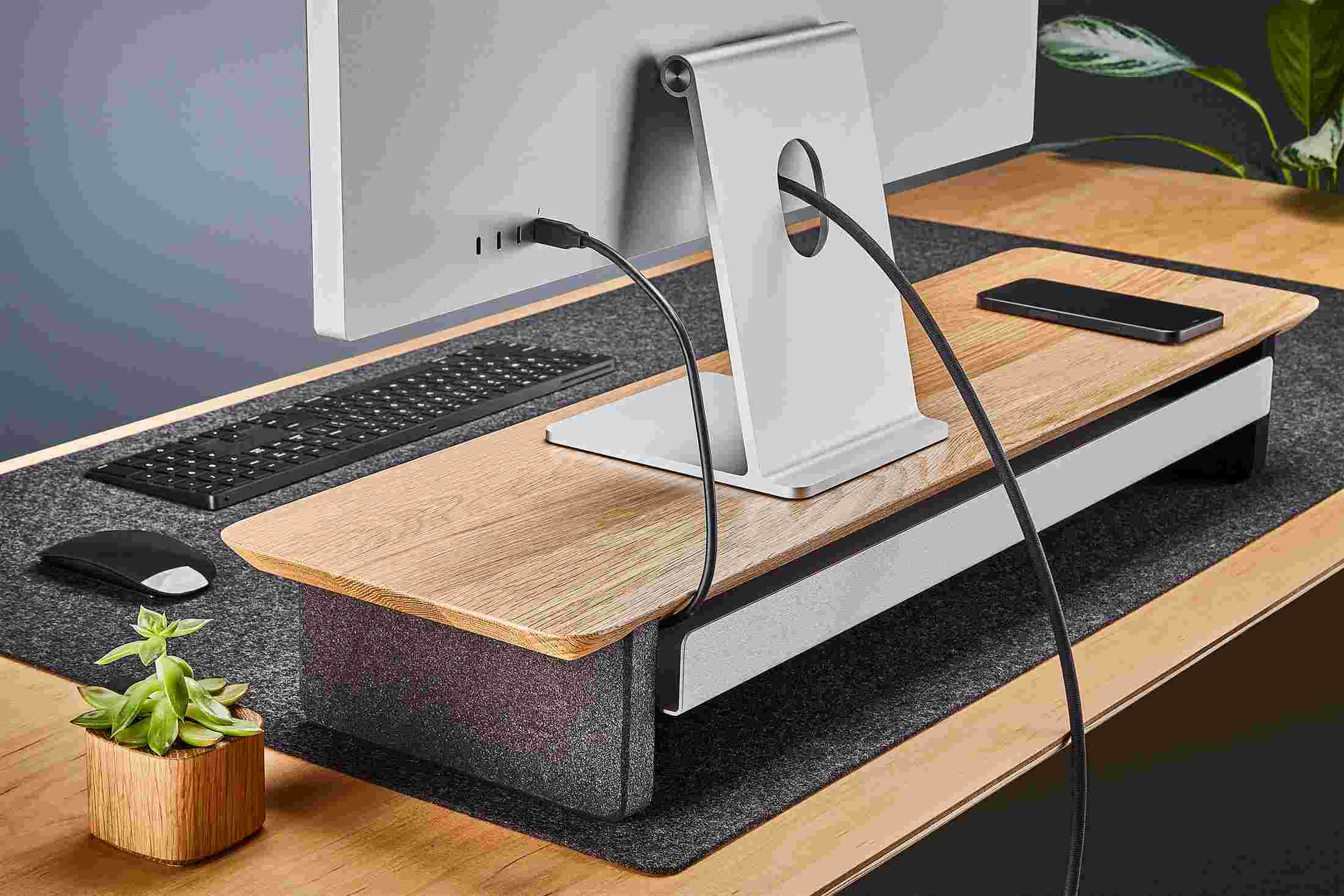 Rear view of the medium white oak monitor organizer showing the back edge of the bent metal shelf, designed to keep your stuff in place, while leaving space for hidden cord access.