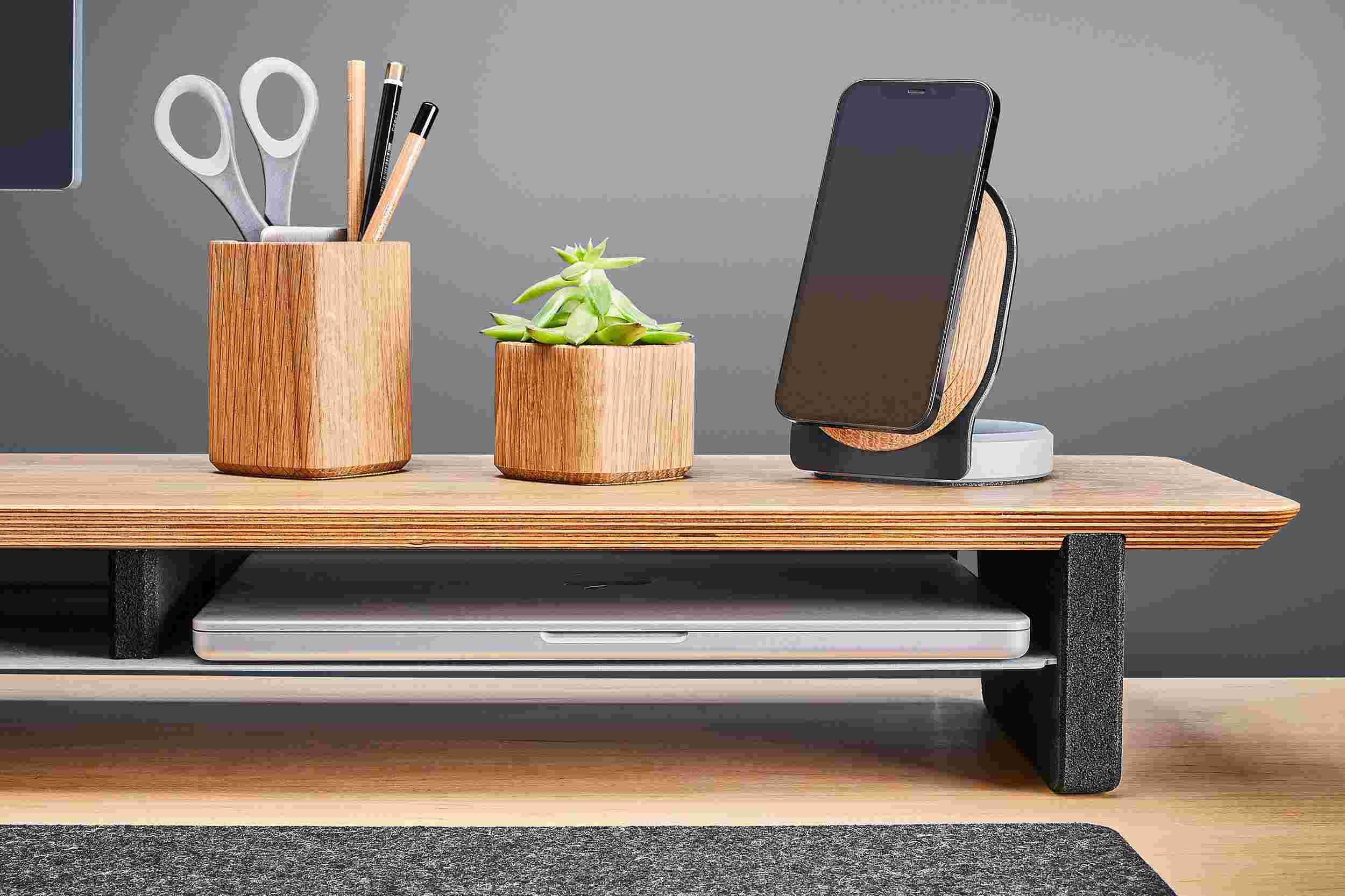 The oak plywood desk shelf's integrated storage shelf holding a MacBook Pro.
