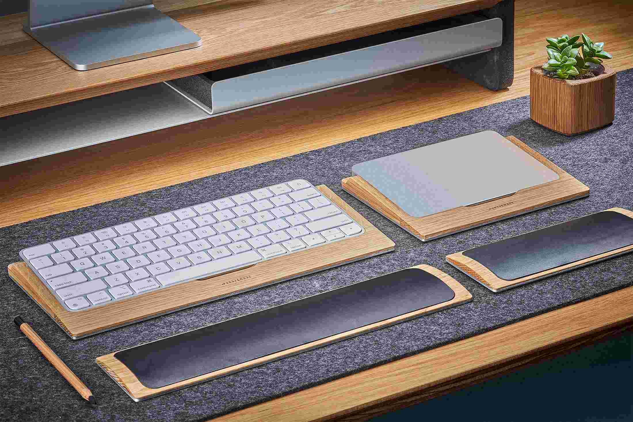 The Oak Keyboard and Trackpad Trays side by side on merino wool felt desk pad.