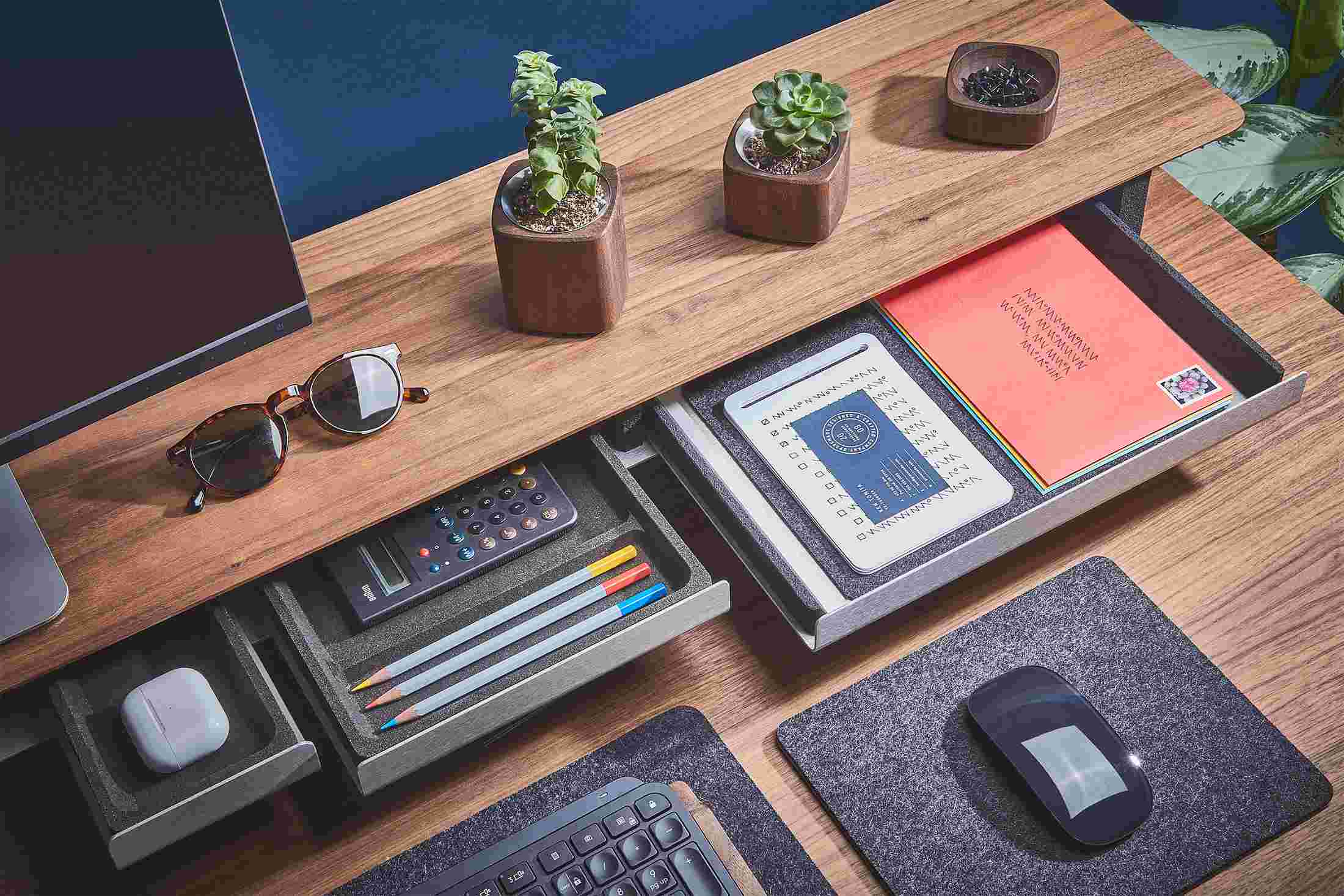 The Dark Paper Tray pulled out from the Walnut Desk Shelf with matching small and medium blackened cork trays.