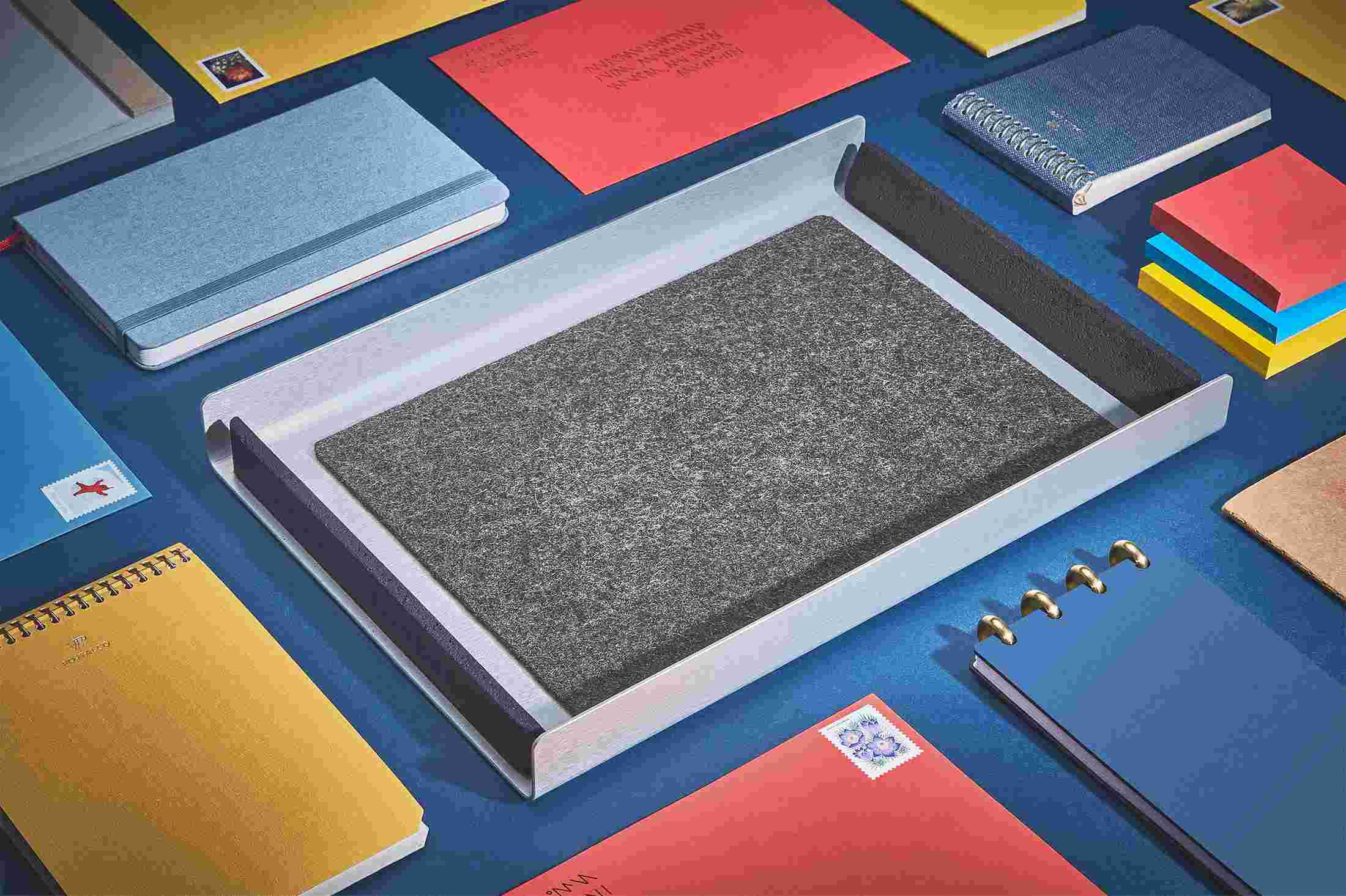 The Dark Paper Tray empty and surrounded by stationery and letters on dark blue.