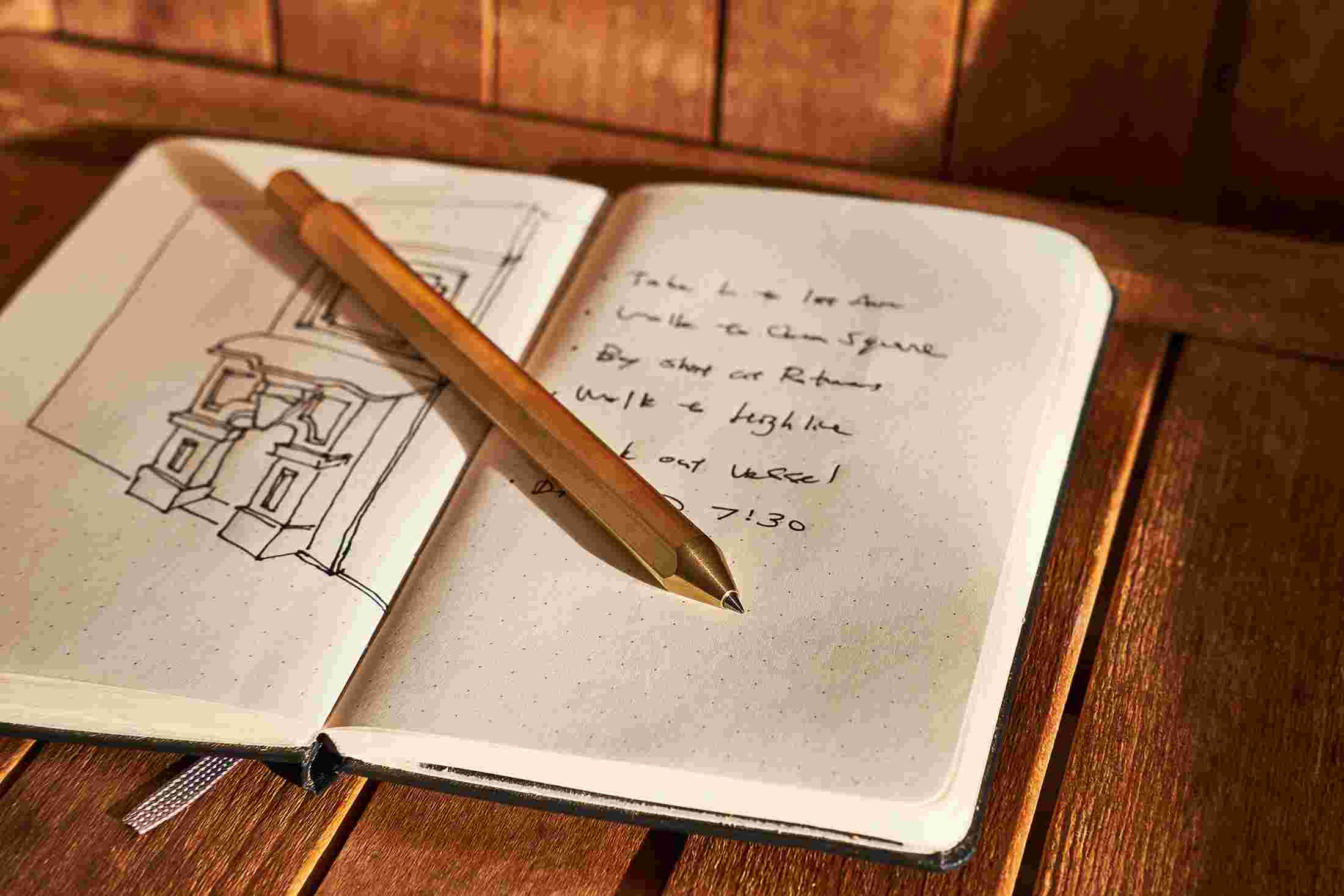 The Grovemade Brass Pen on an open notebook.