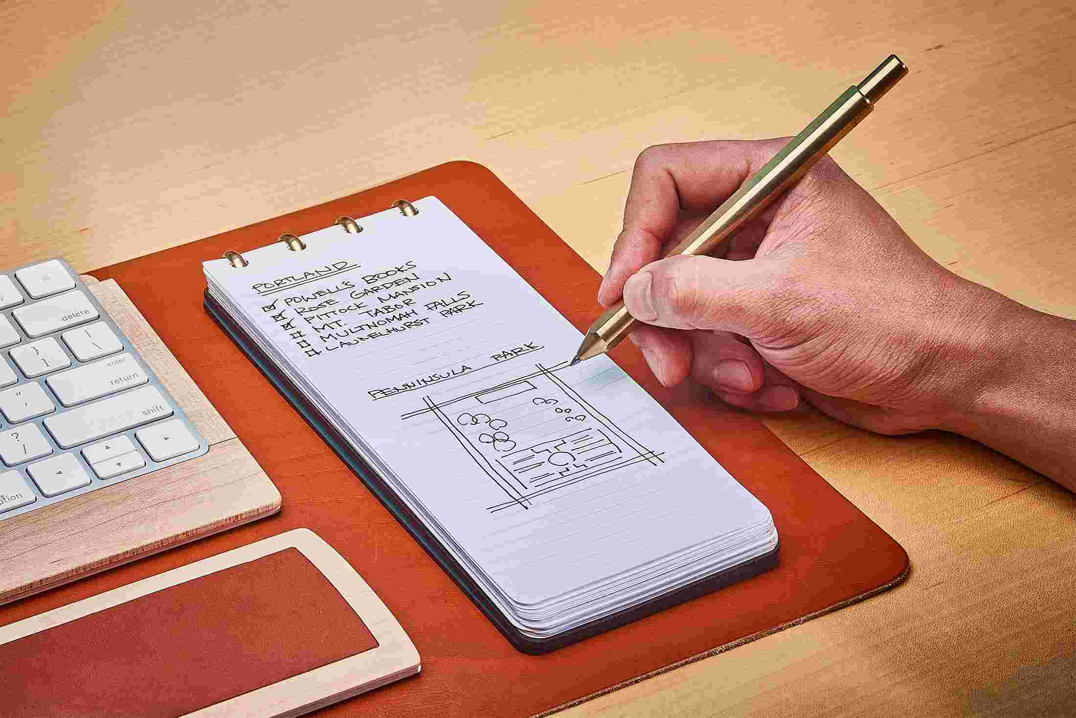 Navy reporter style notebook with cover folded fully back for compact writing.
