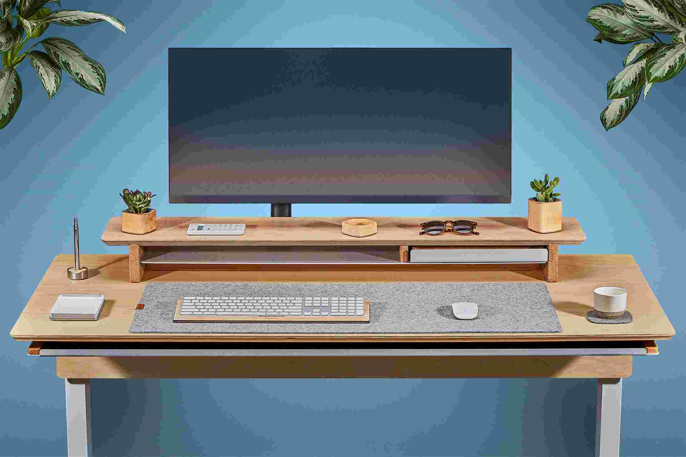 Front view of the solid maple standing desk with matching monitor stand and wool felt desk pad.