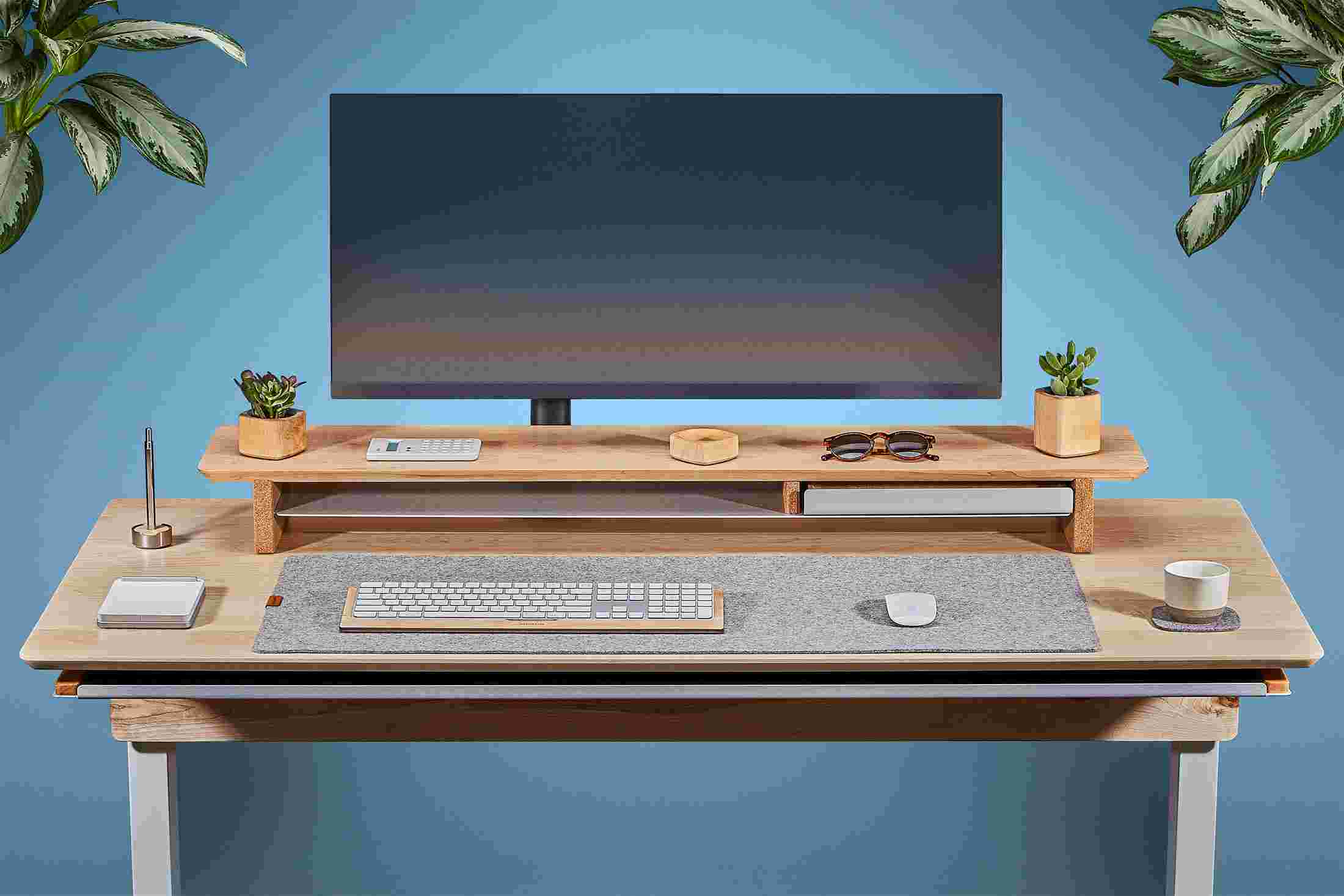 Front view of the solid maple standing desk with matching monitor stand and wool felt desk pad.