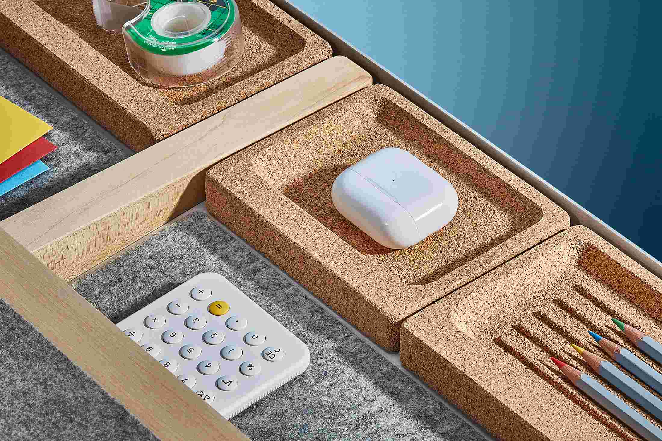 Close up detail of integrated natural cork trays and merino wool felt lining inside of the maple desk drawer.
