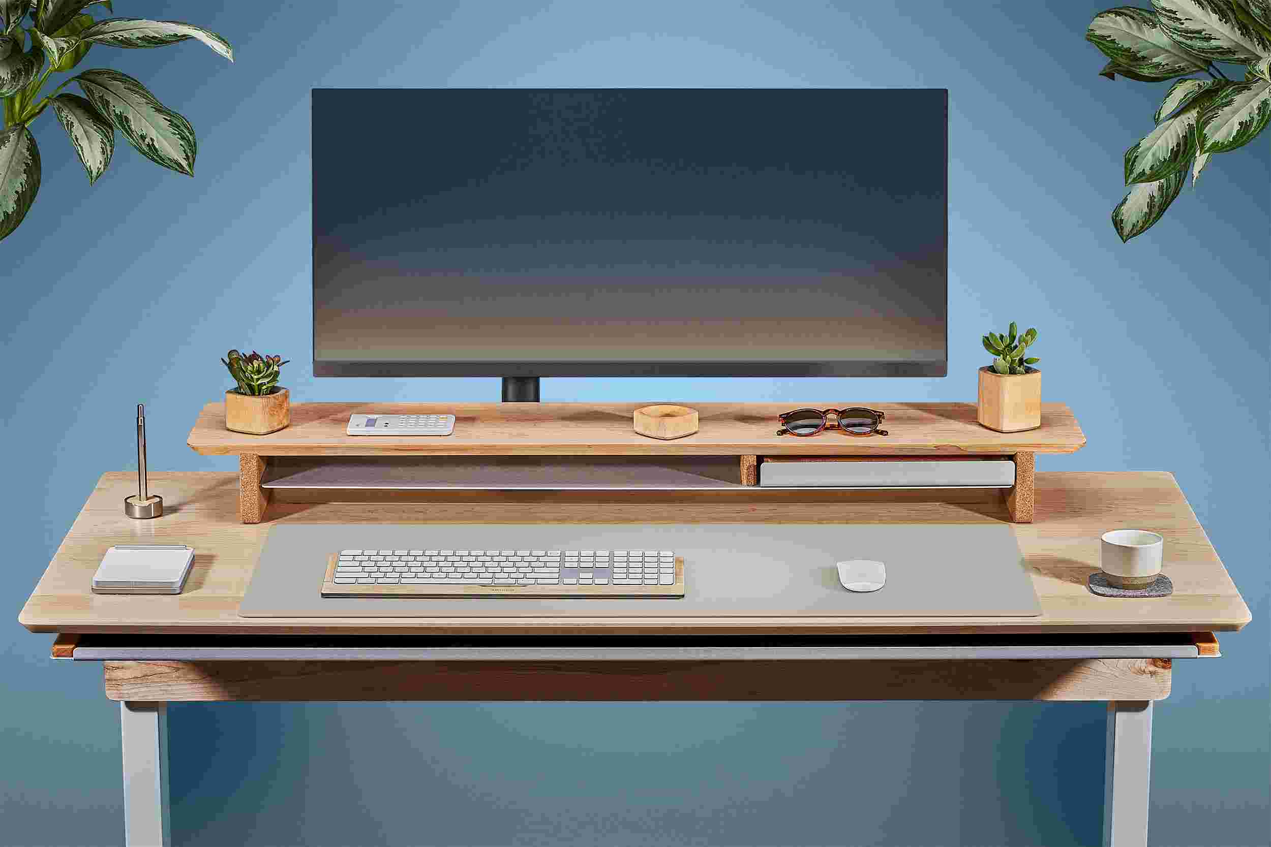 Front view of the solid maple standing desk with matching monitor stand and light grey matte desk pad.