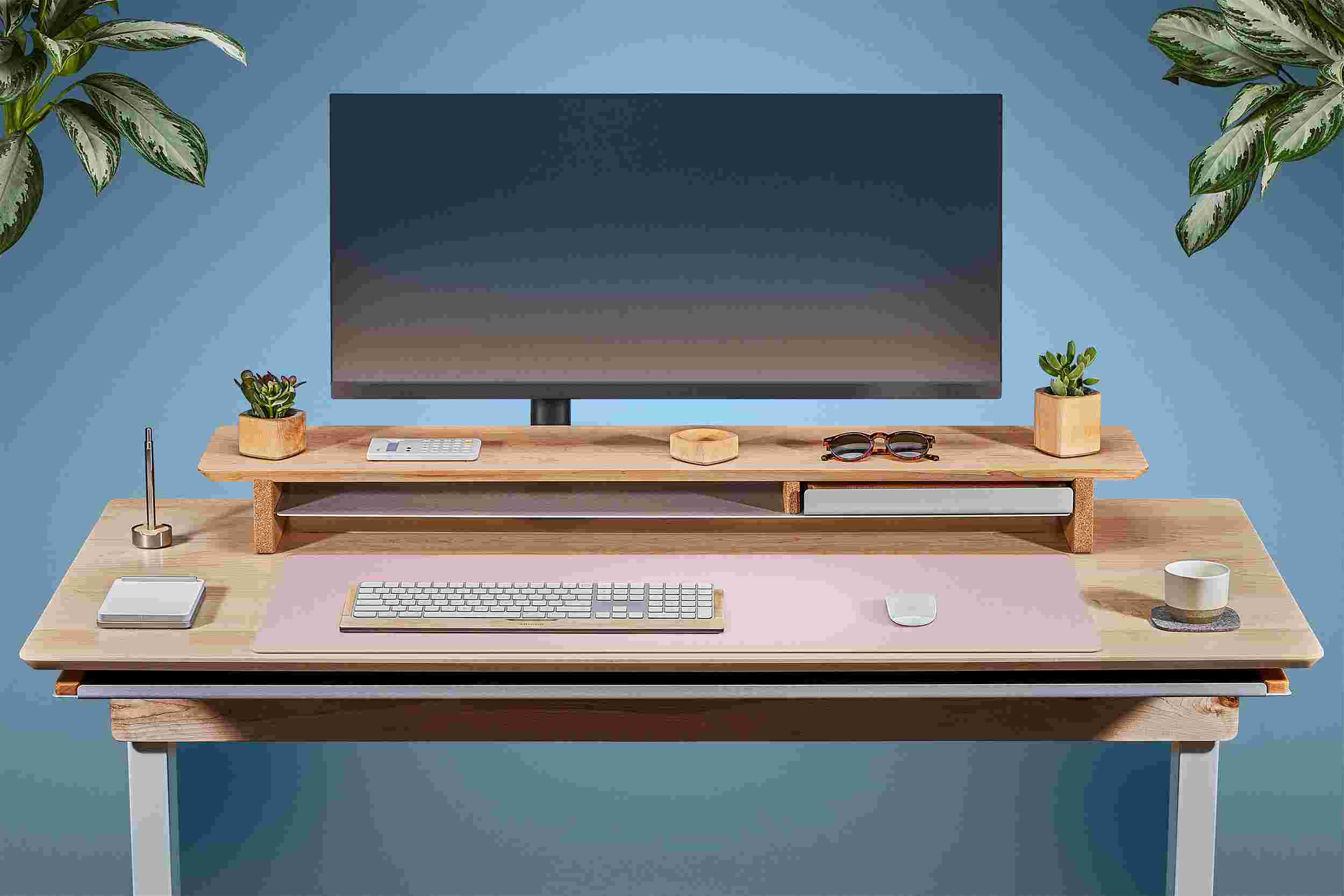 Front view of the solid maple standing desk with matching monitor stand and pink matte desk pad.