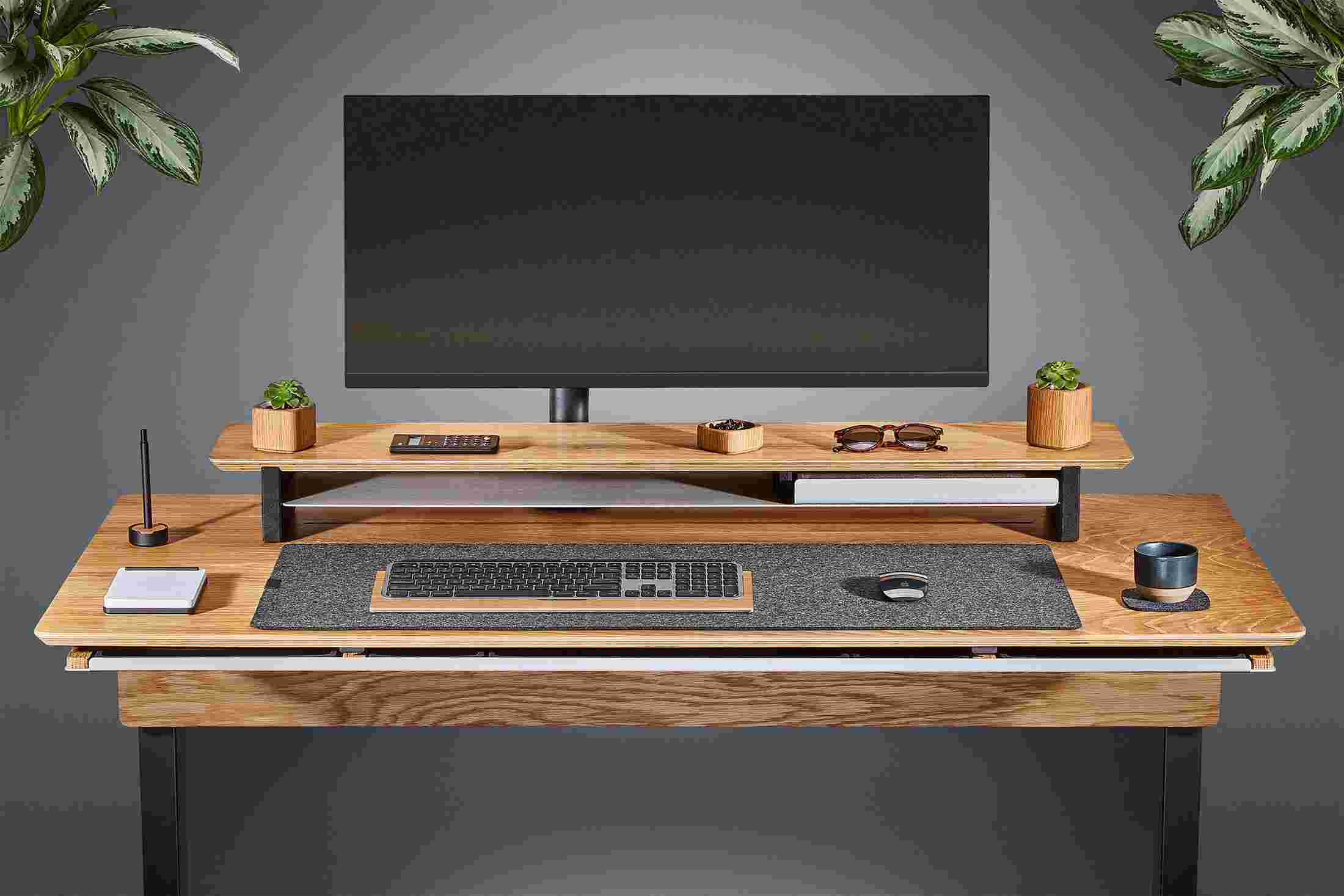 Front view of the oak plywood standing desk with matching monitor stand and wool felt desk pad.