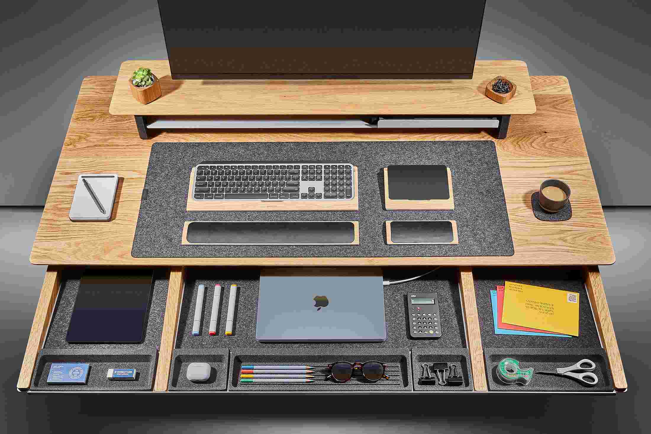 Overhead of the solid white oak desk's massive slide-out drawer, with powered spots for laptops and other devices.