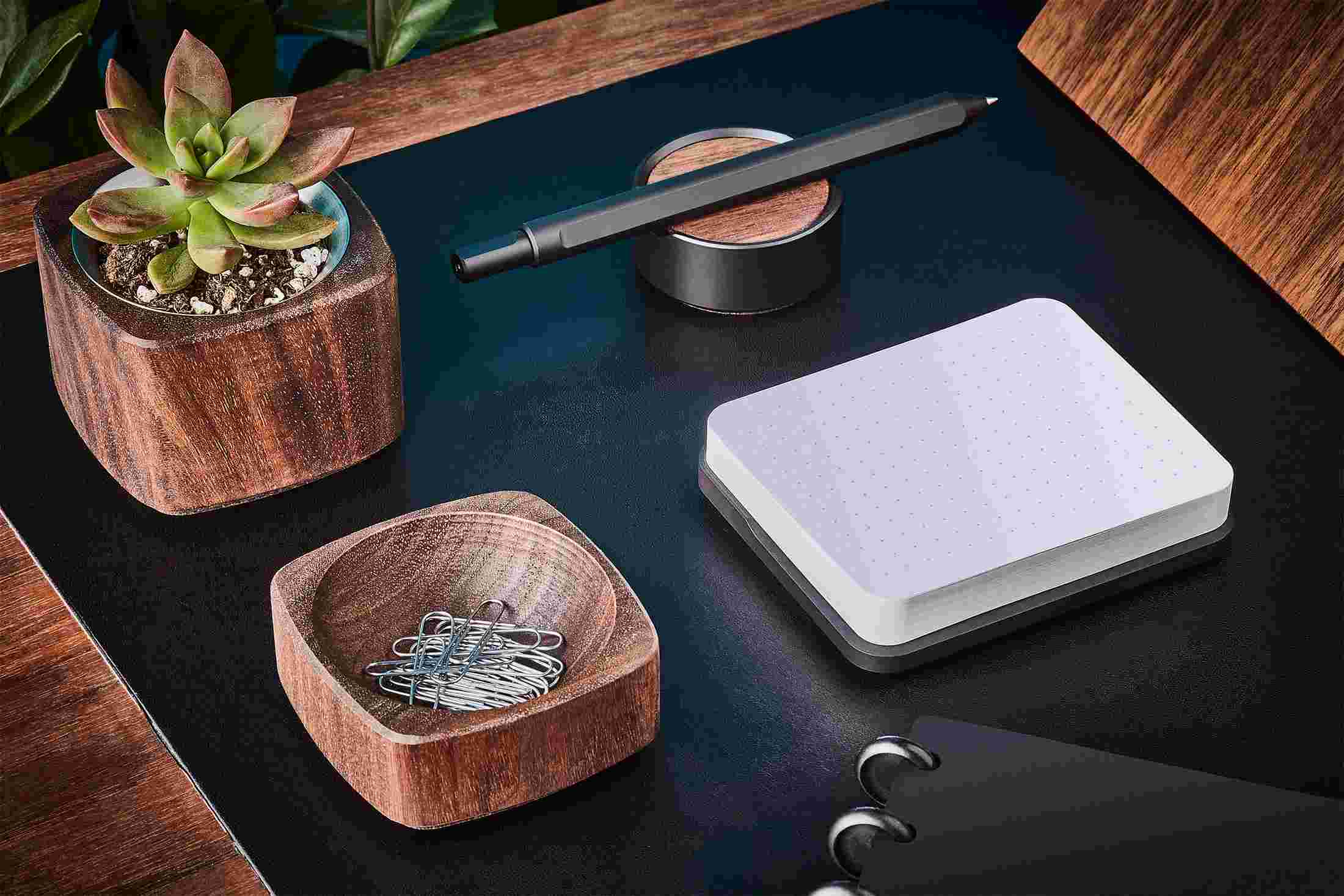 Modern sticky note station in black metal with matching pen and stand.