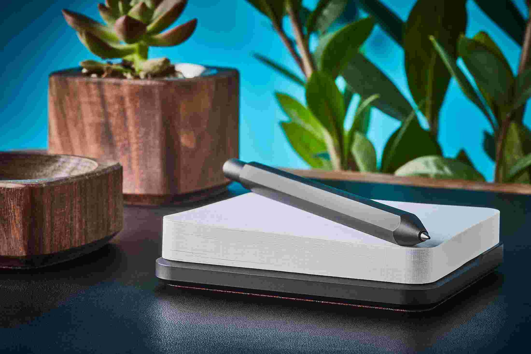 Profile view of premium black pen and sticky note stand.
