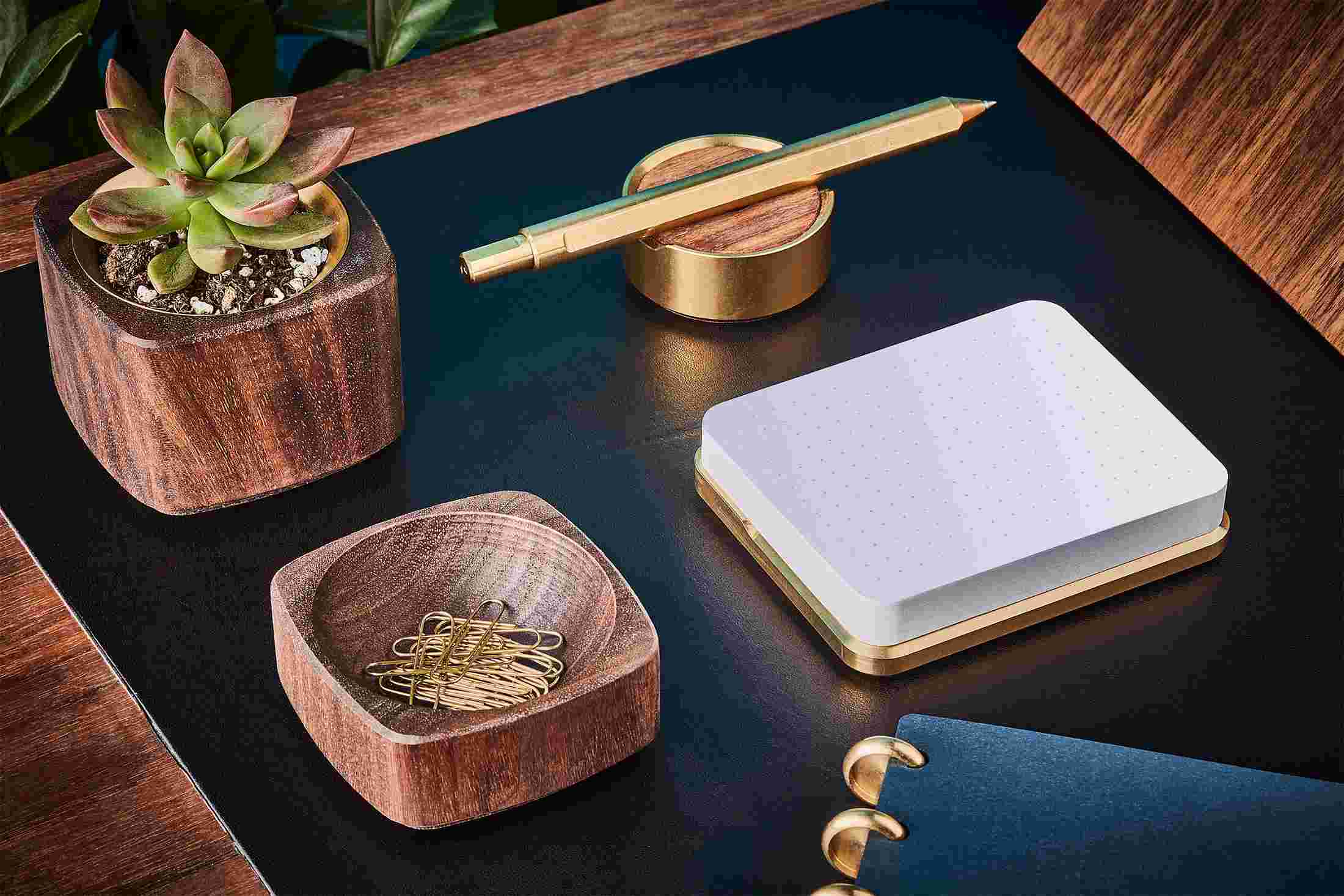 Modern sticky note station in brass with matching pen and stand.