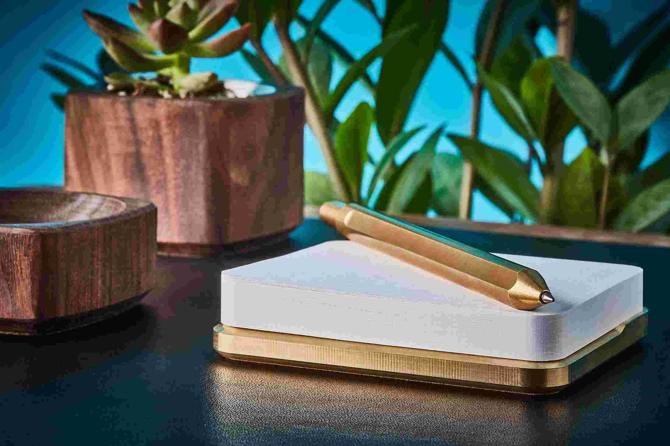 Profile view of premium brass pen and sticky note stand.