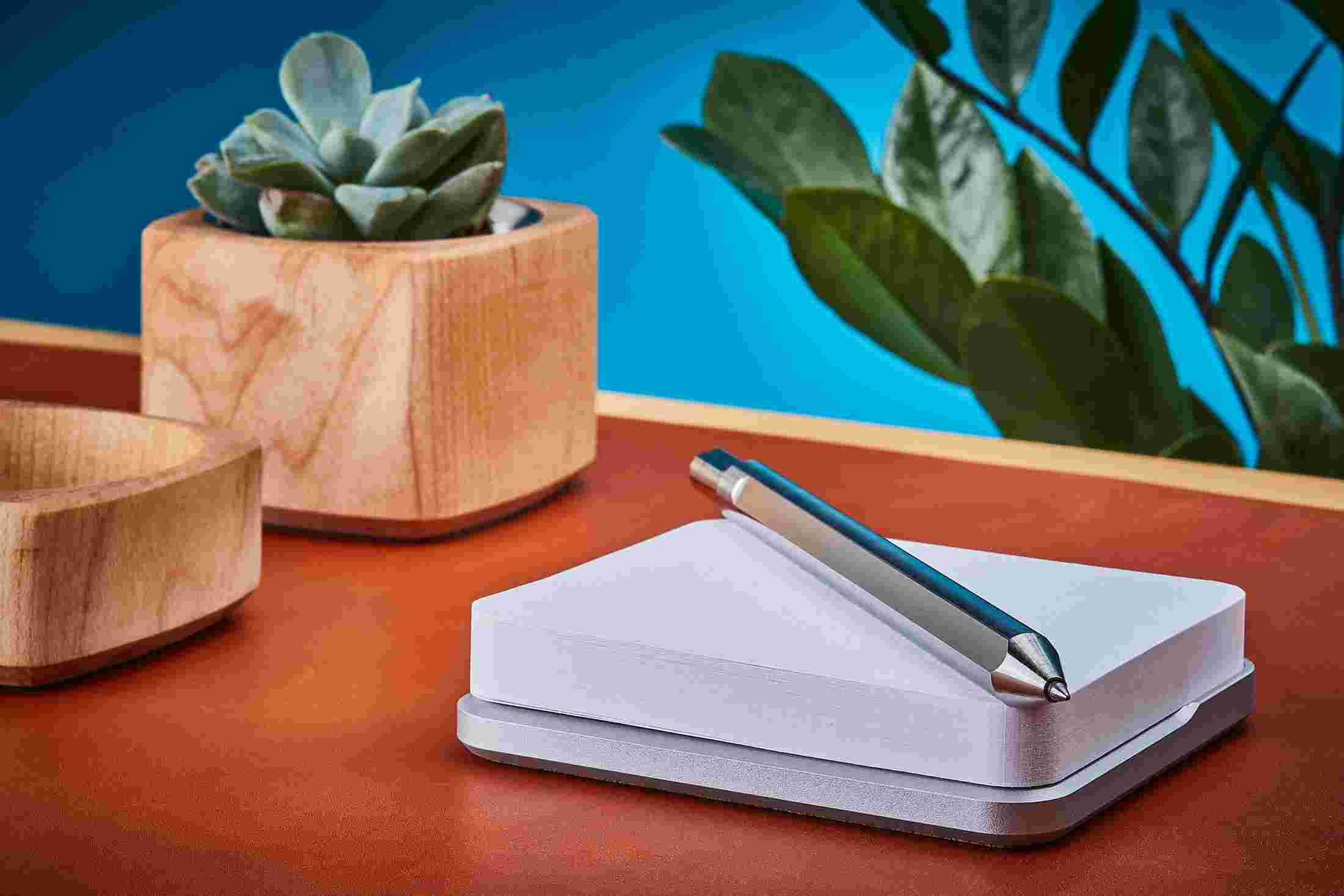 Profile view of premium titanium pen and steel sticky note stand.