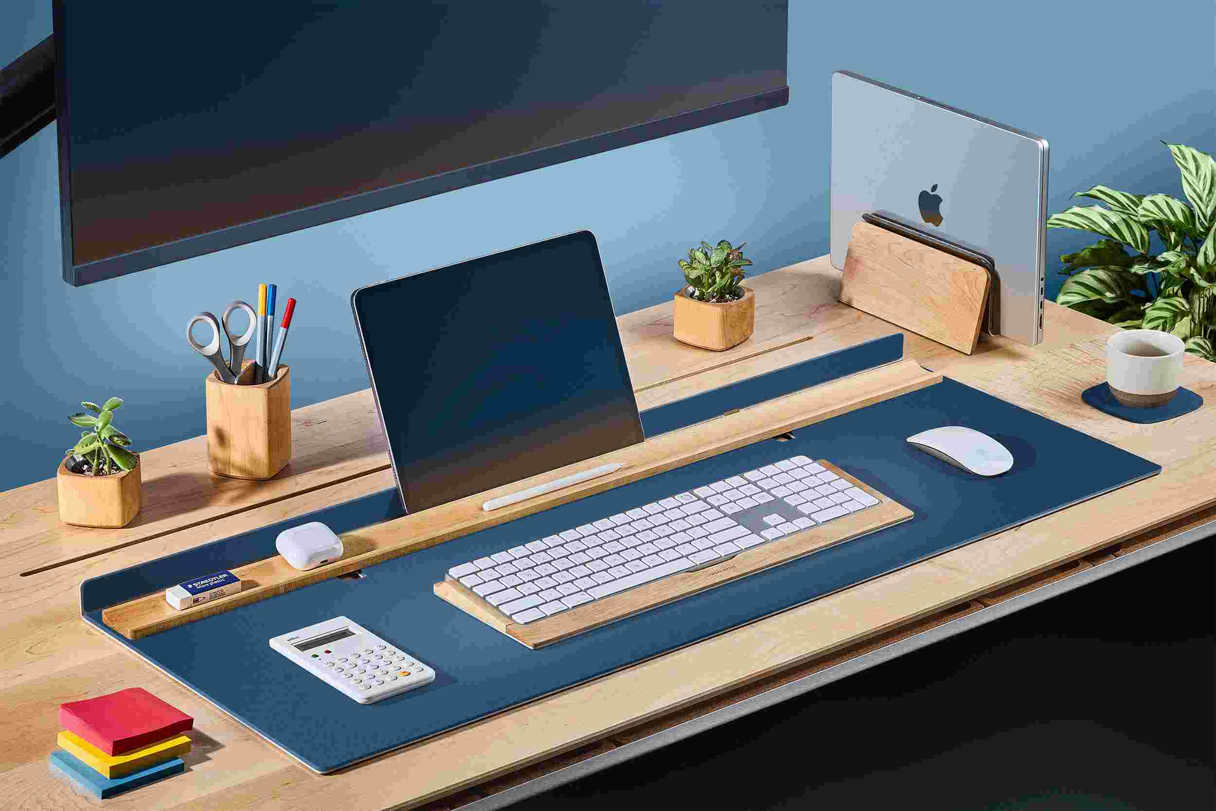 Navy blue desk station with matching wood keyboard tray and MacBook stand.