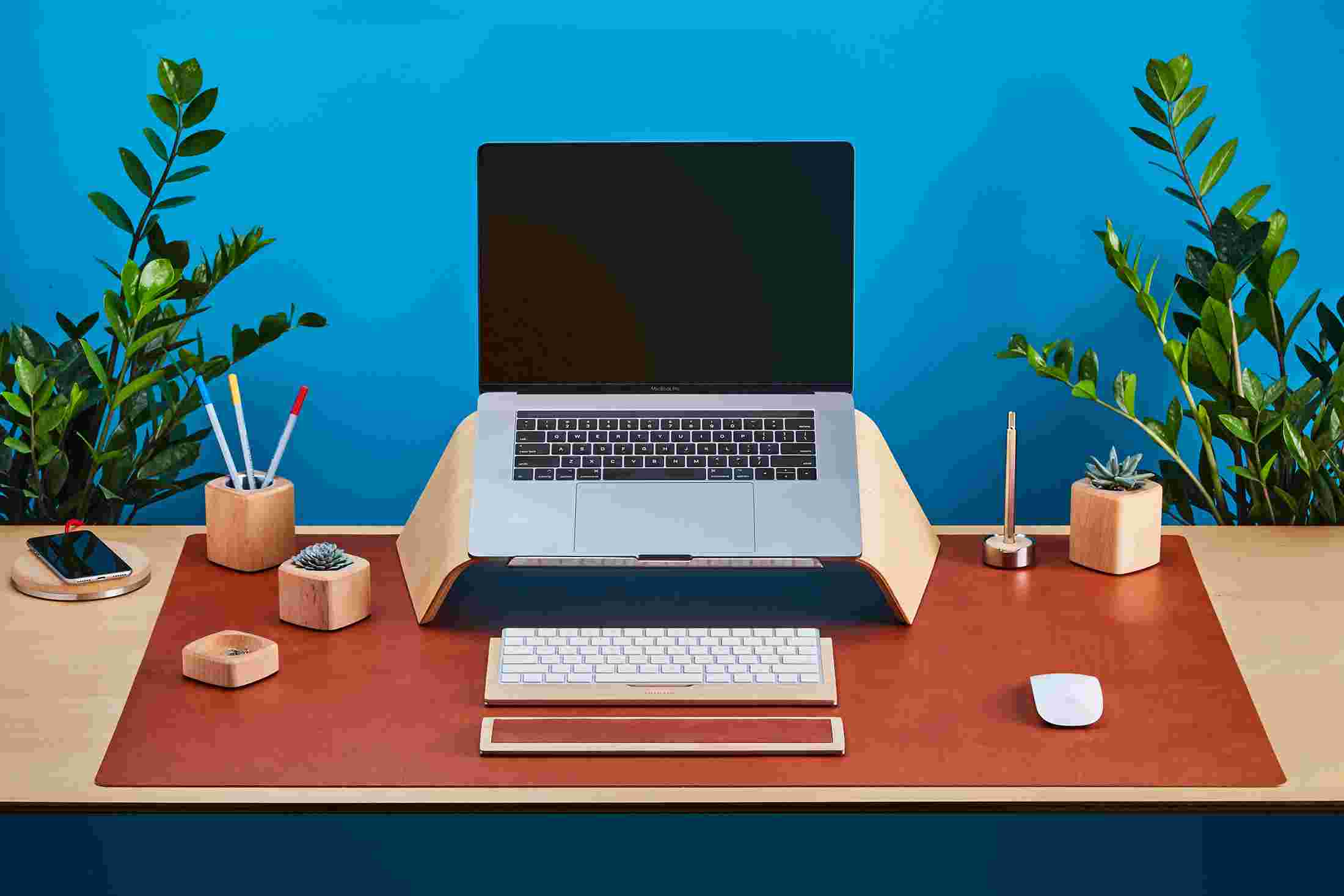 Maple Wood Grovemade Desk Collection with Maple laptop stand, pen cups, desk lamps, planter, leather mouse pad, leather wrist pad, and keyboard tray.