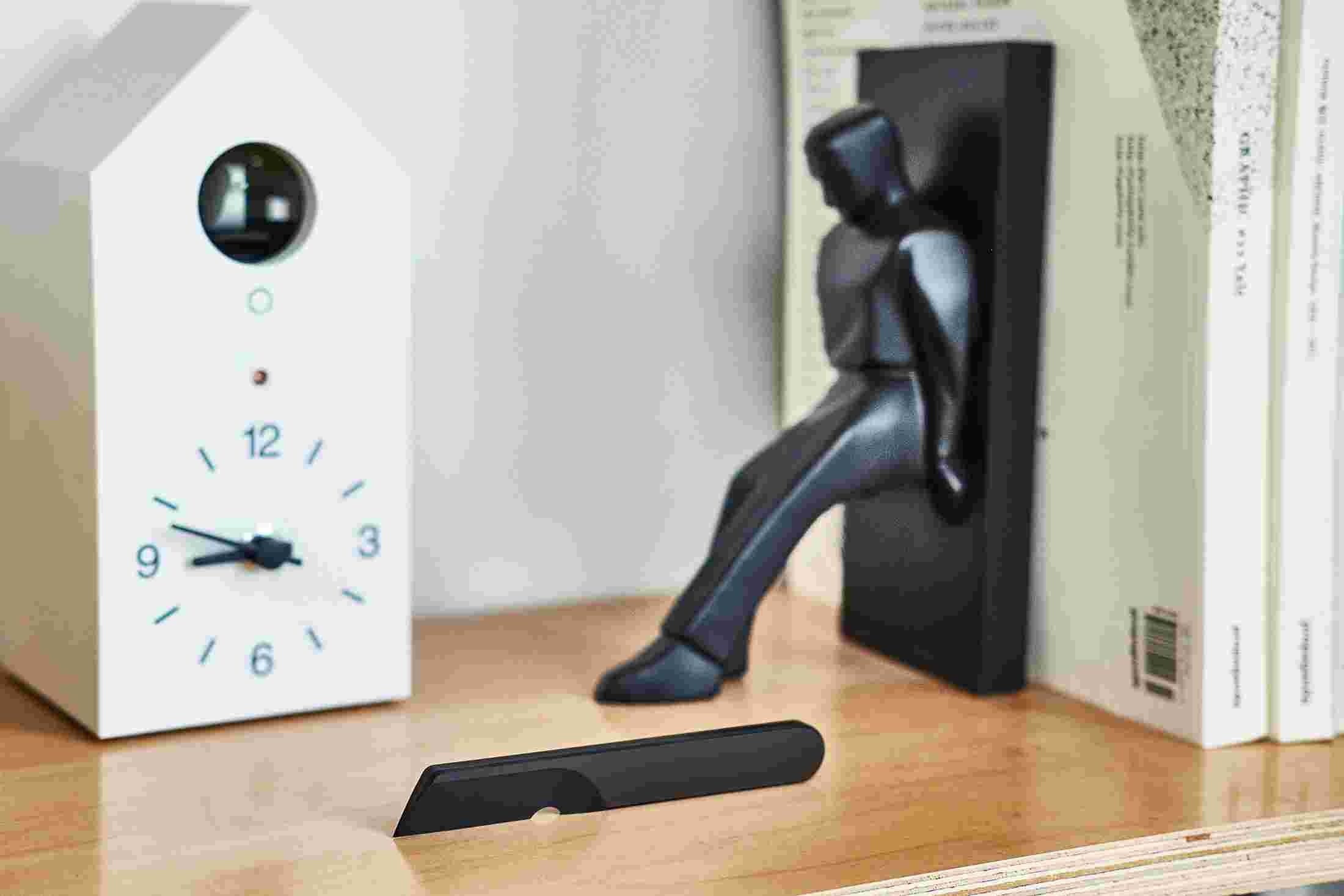 Single-piece, modern metal knife in matte black on bookshelf.