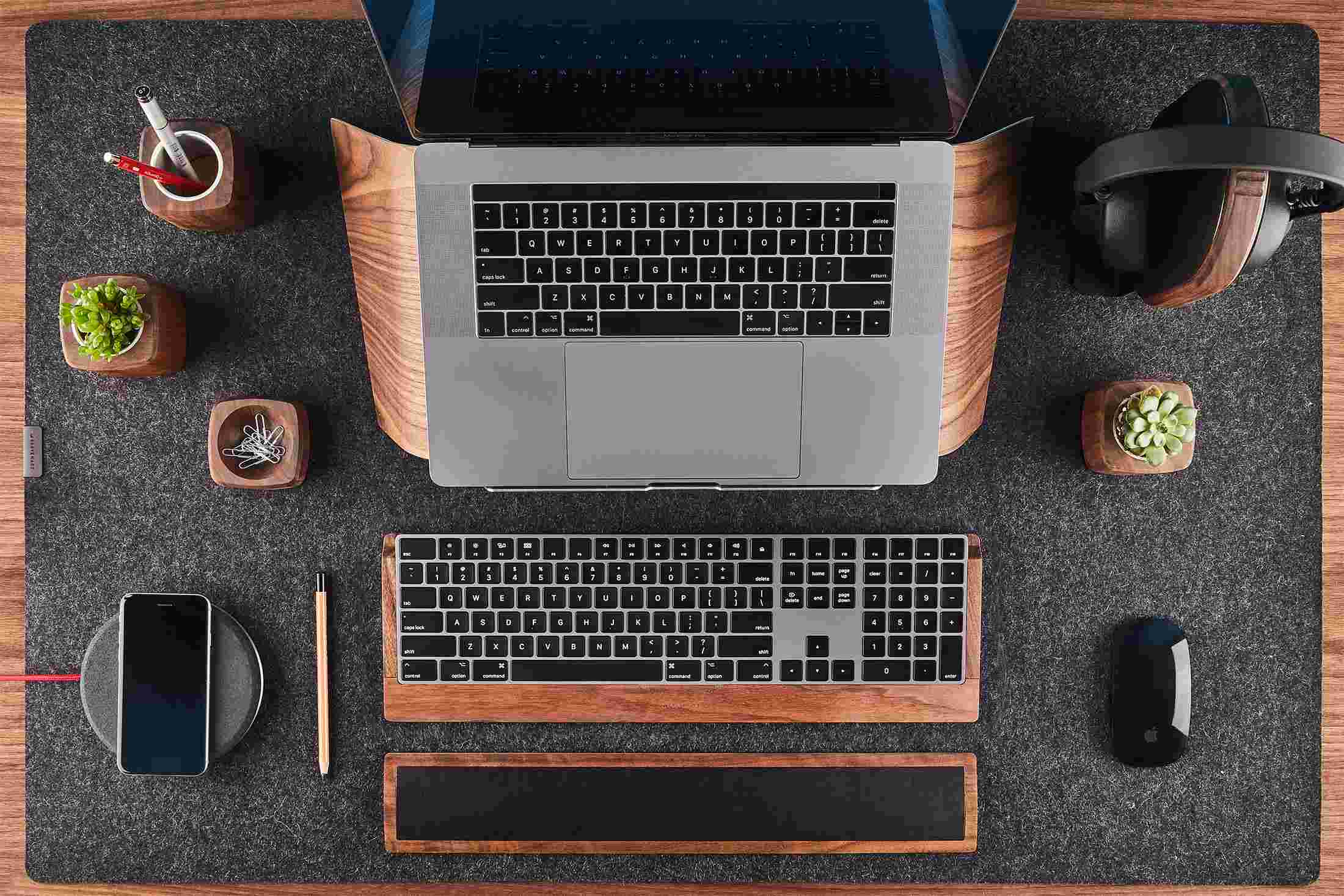 Overhead view of the Walnut Wood Laptop Stand with 10-key keyboard tray and wrist pad on wool felt desk pad.