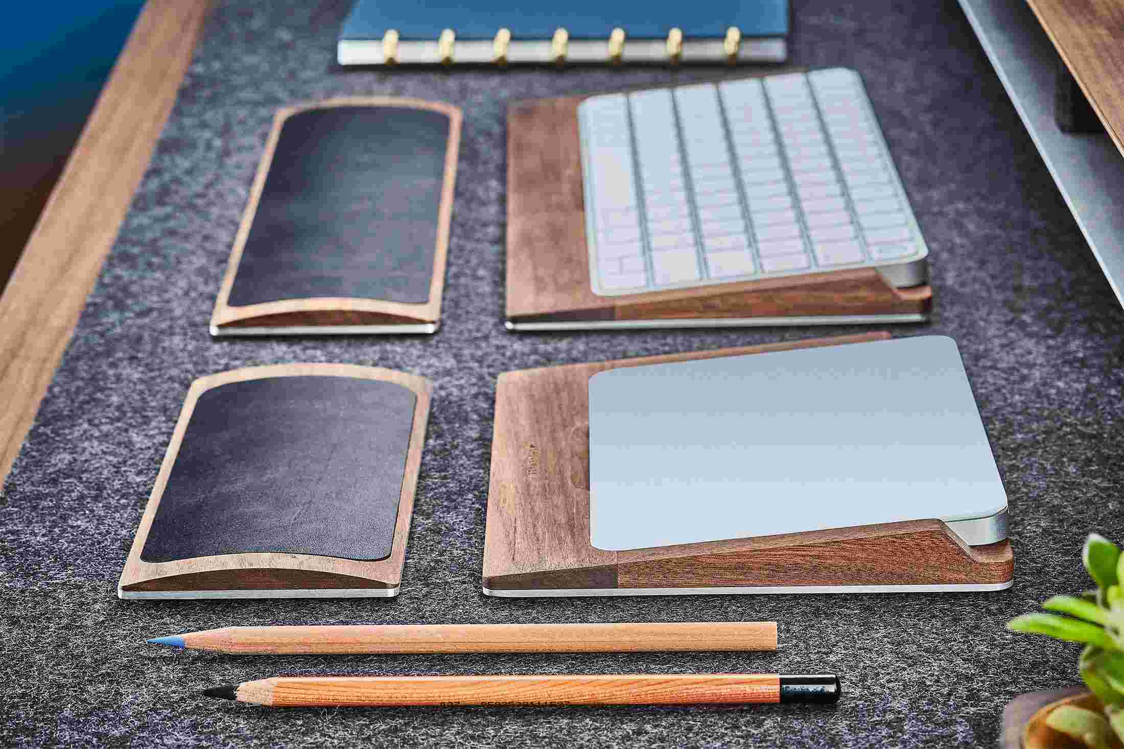 Detail of the steel and walnut wood trackpad tray with matching black leather wrist rest.