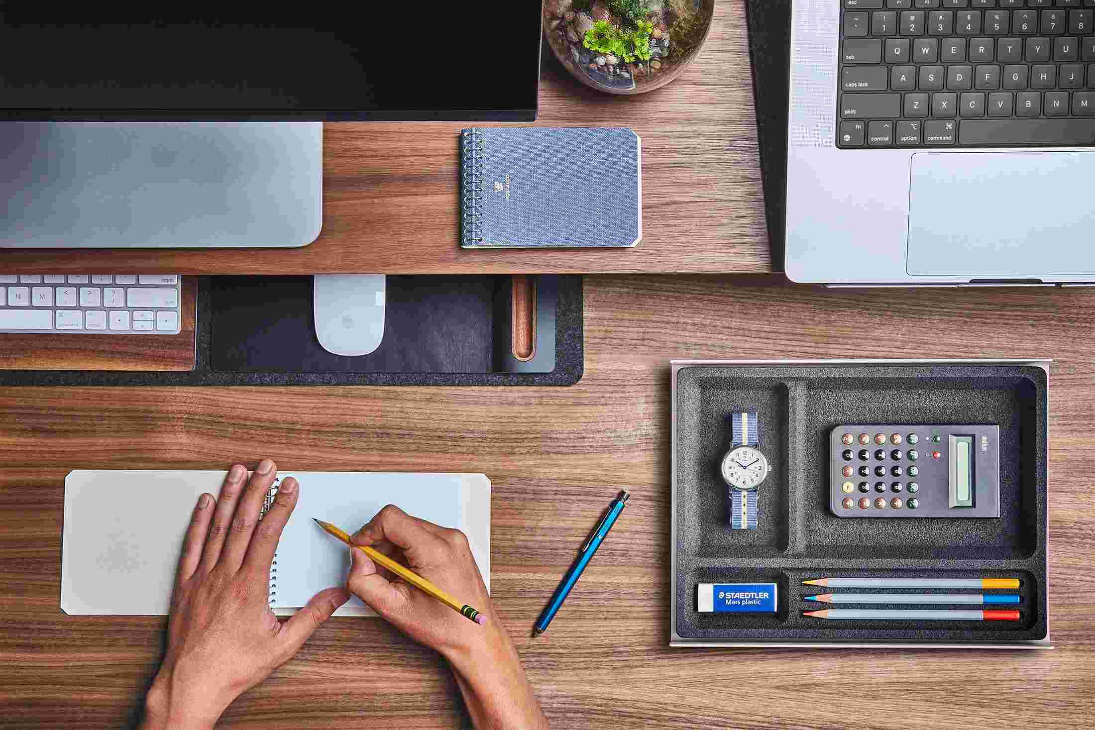 The small desk pad with keyboard and mouse slid under the walnut desk shelf to free up working space.