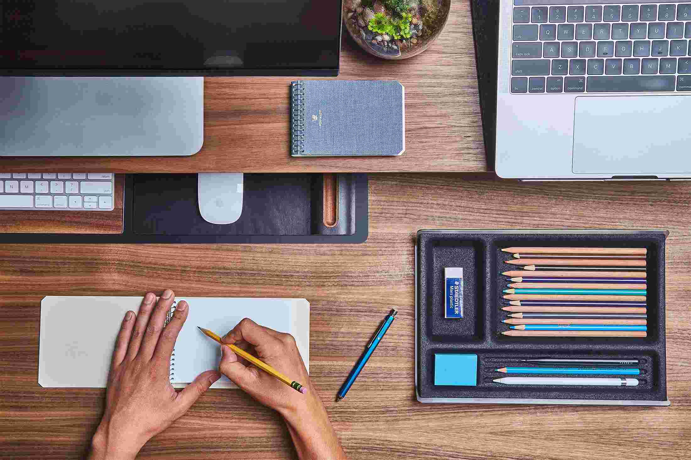 The Small Matte Black Desk Pad tucked under the Walnut Desk Shelf, creating space for other work.