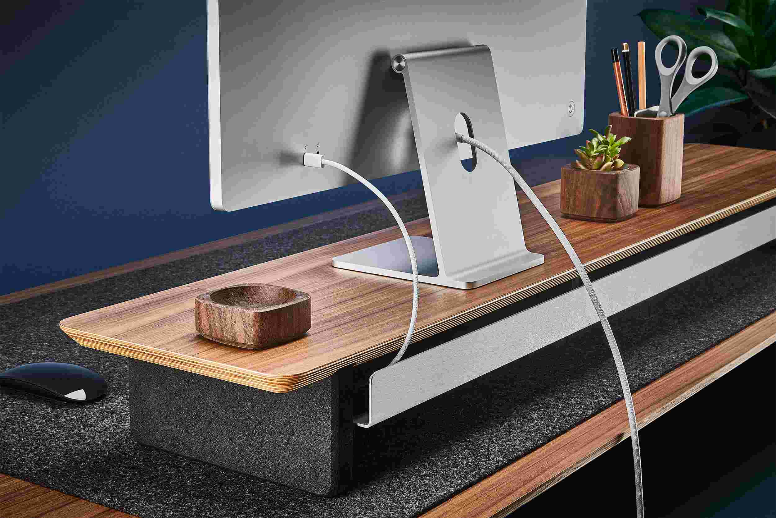 Rear view of the walnut shelf showing the back edge of the bent metal shelf, designed to keep your stuff in place, while leaving space for hidden cord access.