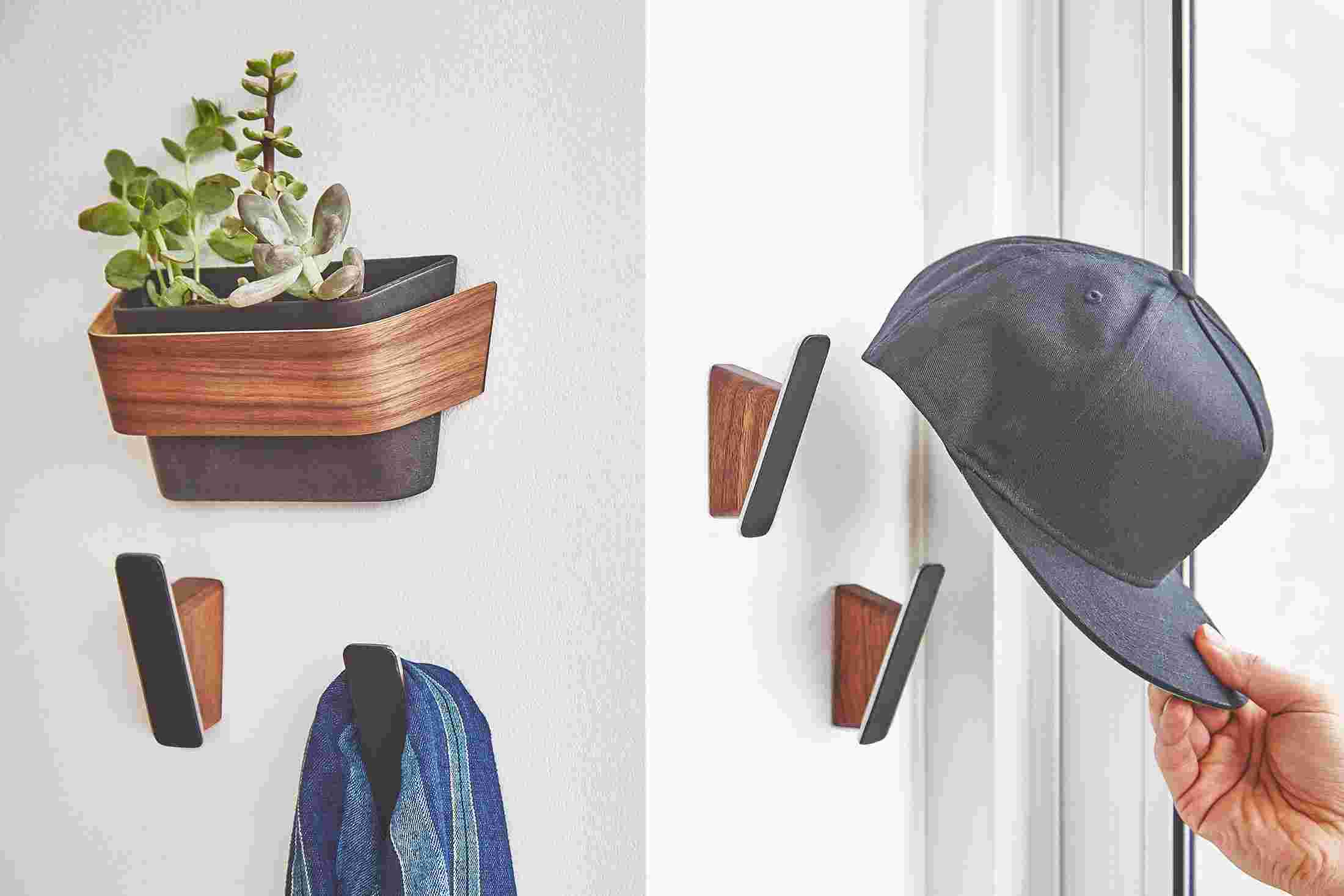 Set of four walnut and leather coat hooks.