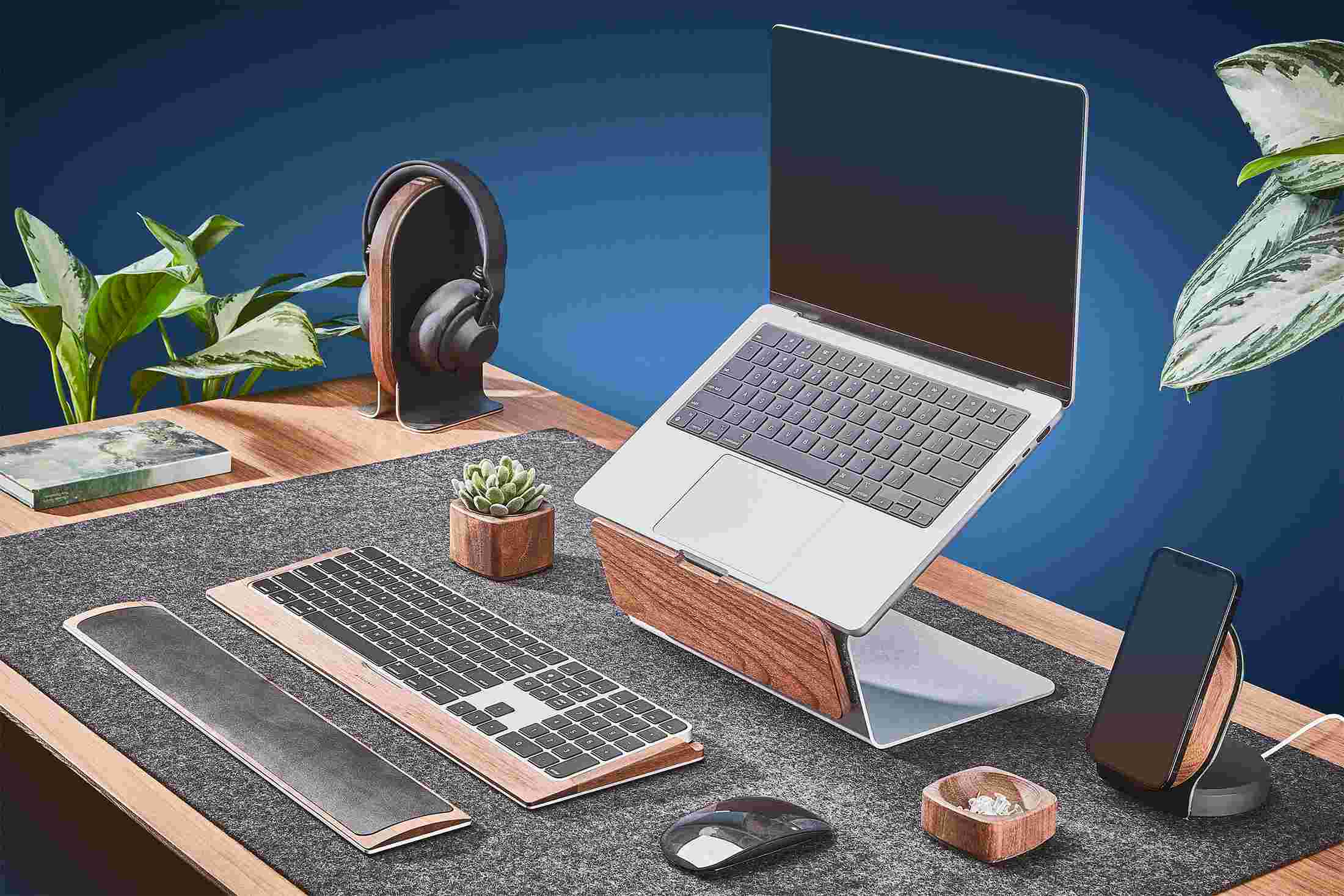 Walnut laptop riser on extra large black leather desk pad.
