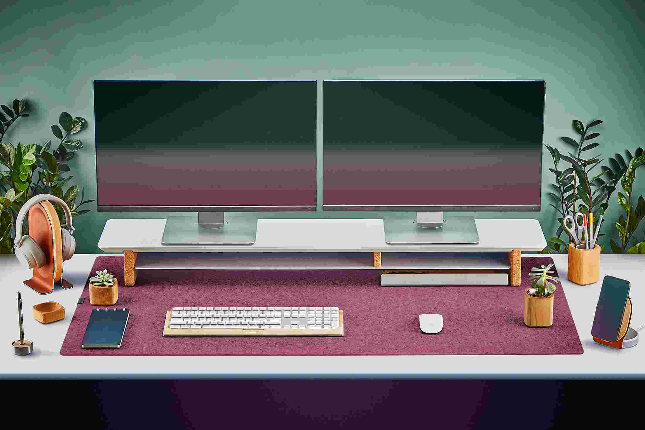 The Extra Large Wool Felt Desk Pad in Dark Pink covering almost an entire desktop, in use with the Matte White Desk Shelf System.