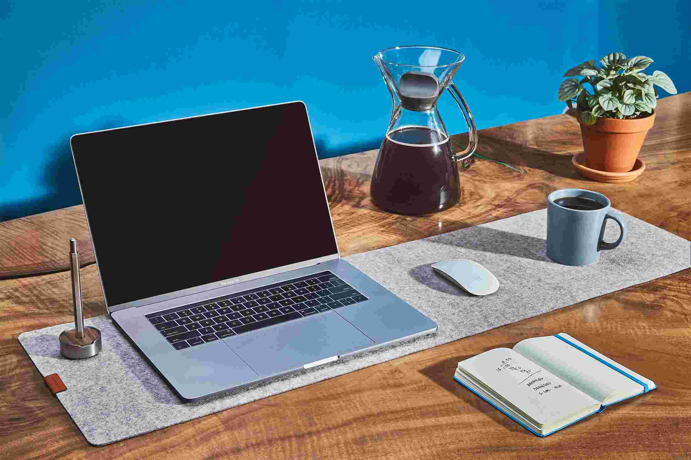 The Medium Light Felt Desk Pad used as a combination laptop pad, mousepad, and coffee coaster.