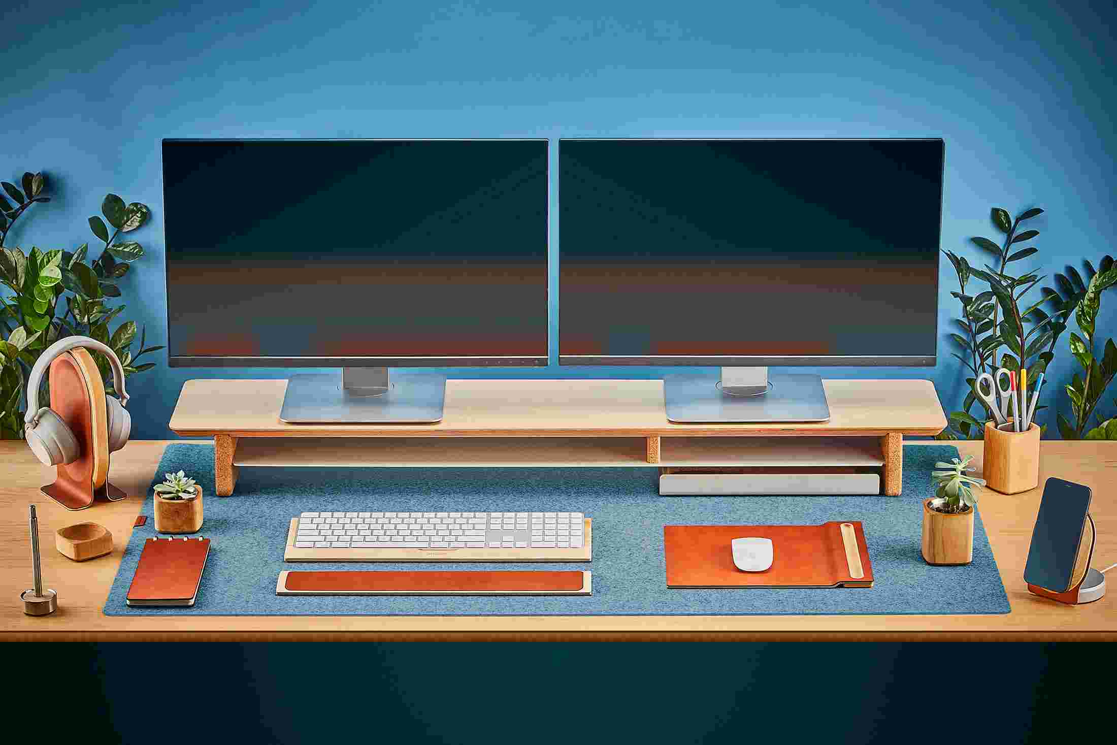 The Extra Large Wool Felt Desk Pad in Light Blue covering almost an entire desktop, in use with the Maple Desk Shelf System.