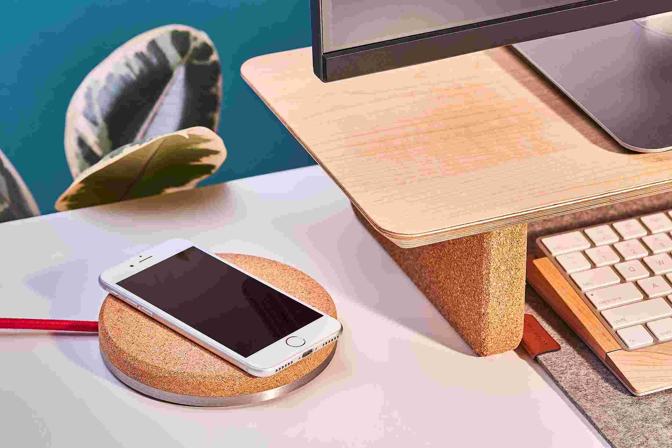 The iPhone Charging Pad topped with natural cork, matching the cork leg of the maple desk shelf.