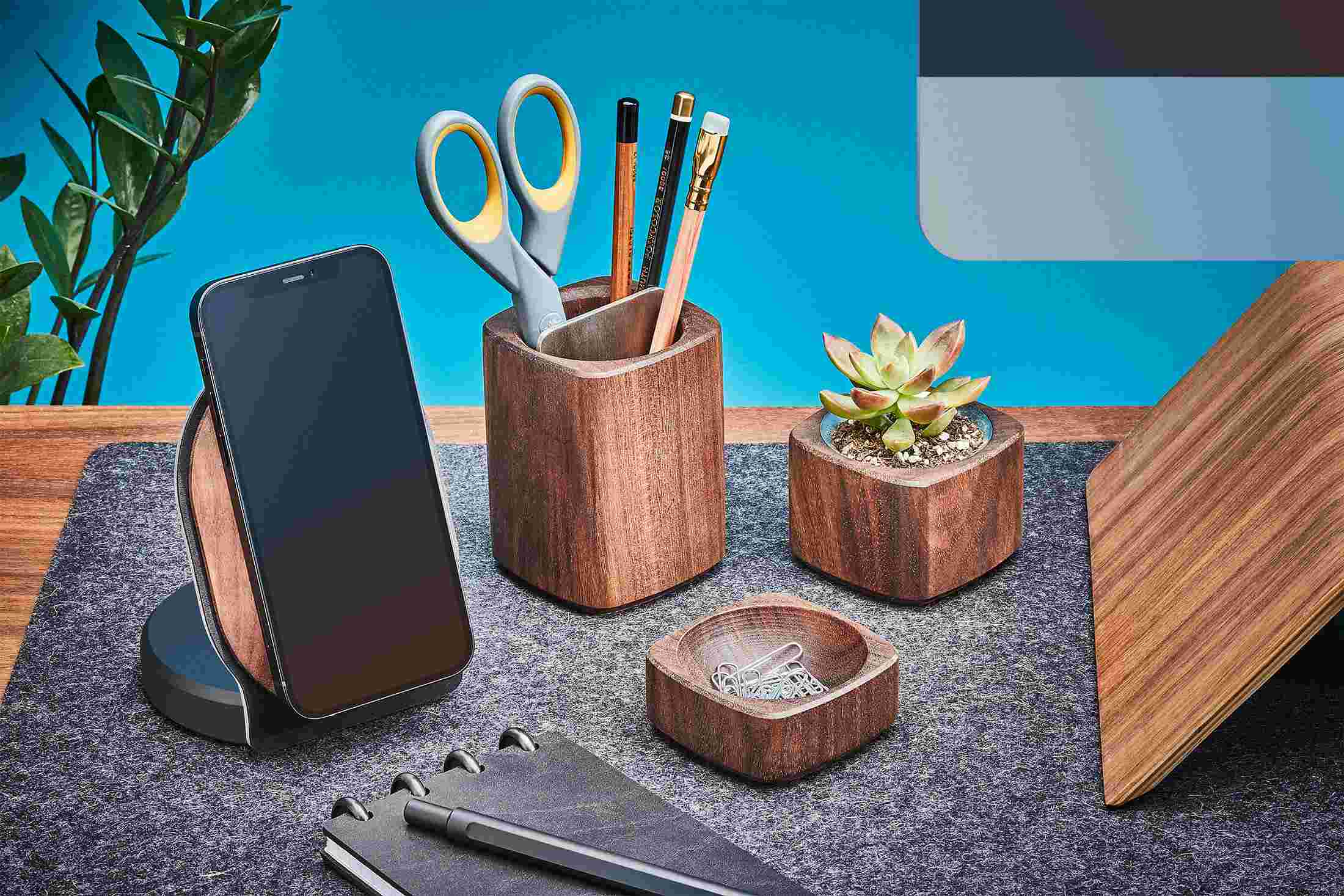 Walnut wood iPhone 12 MagSafe Holder on wool felt desk pad with matching desk accessories.